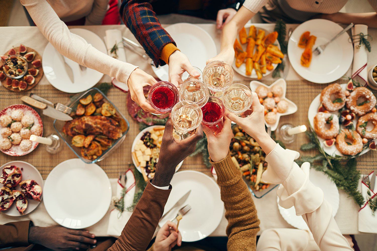 Friends raising their drinking glasses at a large dining table