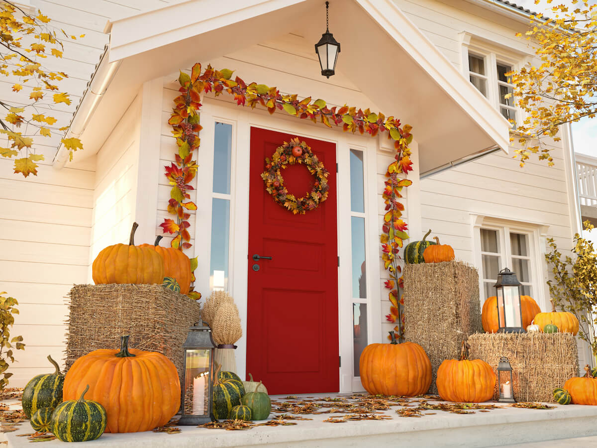 Halloween house decor: doorway decorated with pumpkins and fall leaves