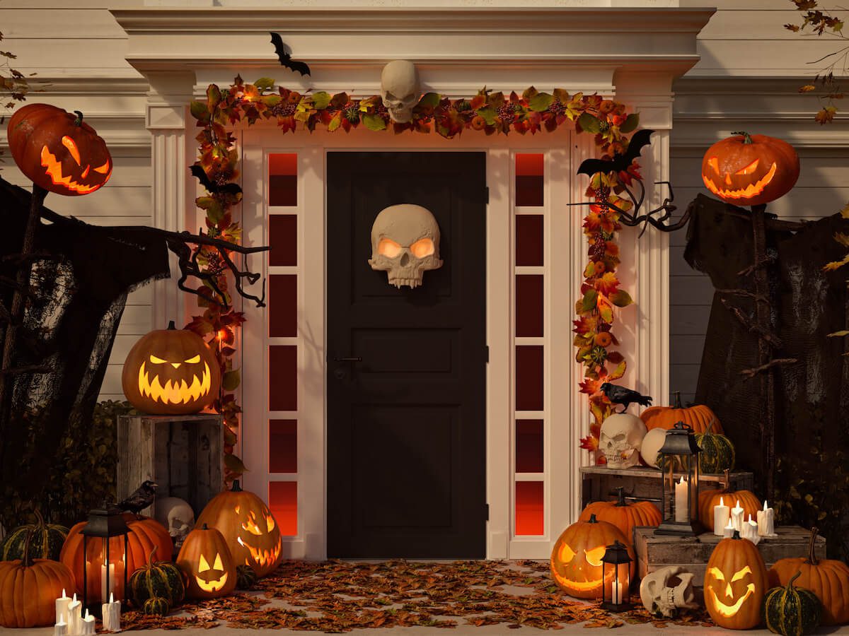 Halloween house decorations: front door with skull and scary pumpkins