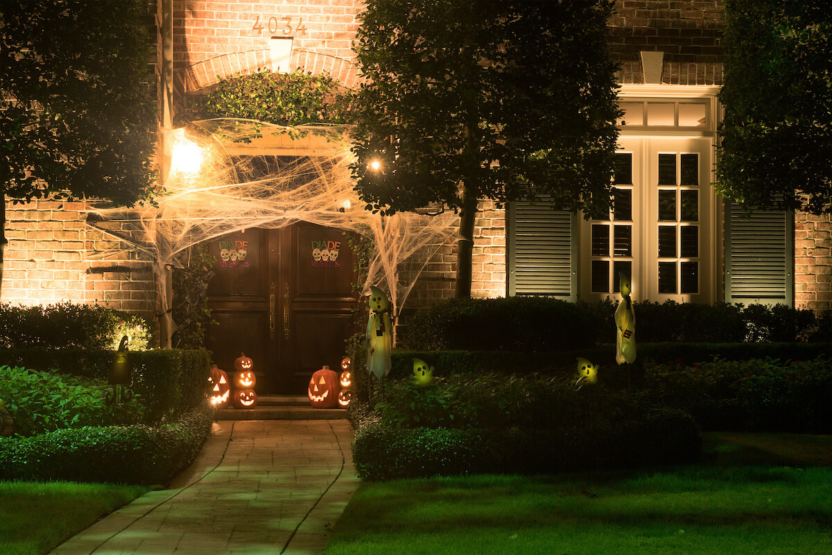 House decorated with carved pumpkins and webs