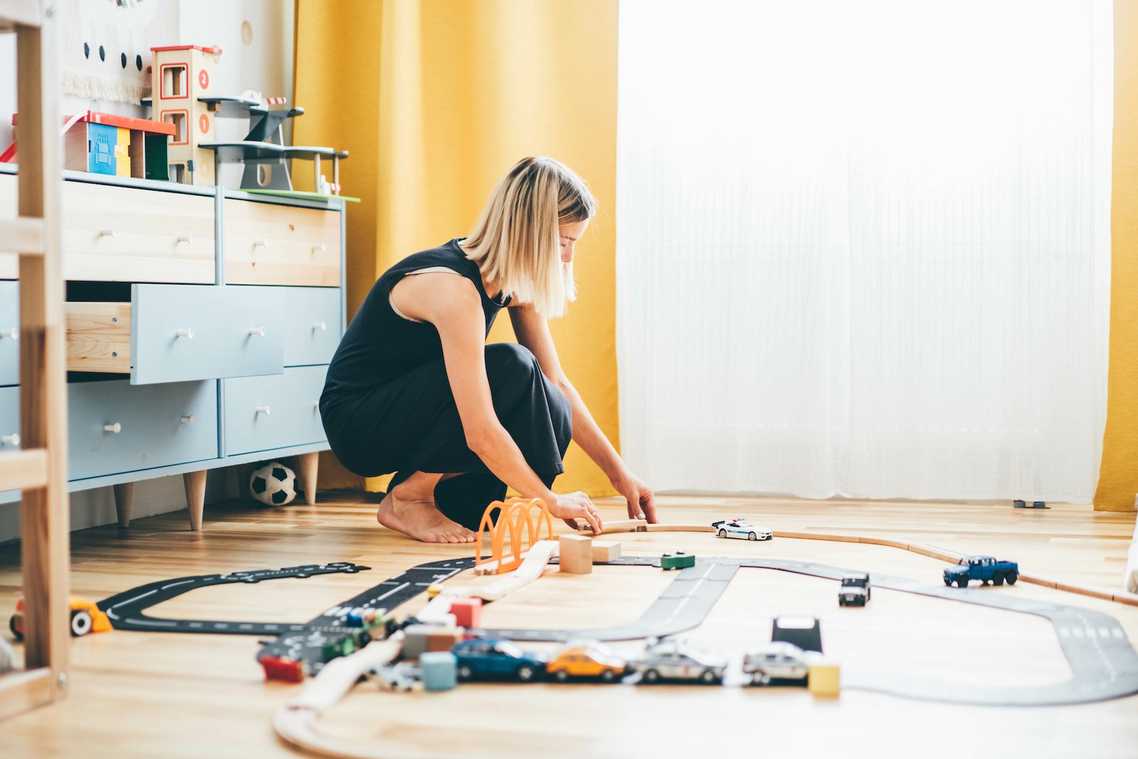 woman assembling a toy race track