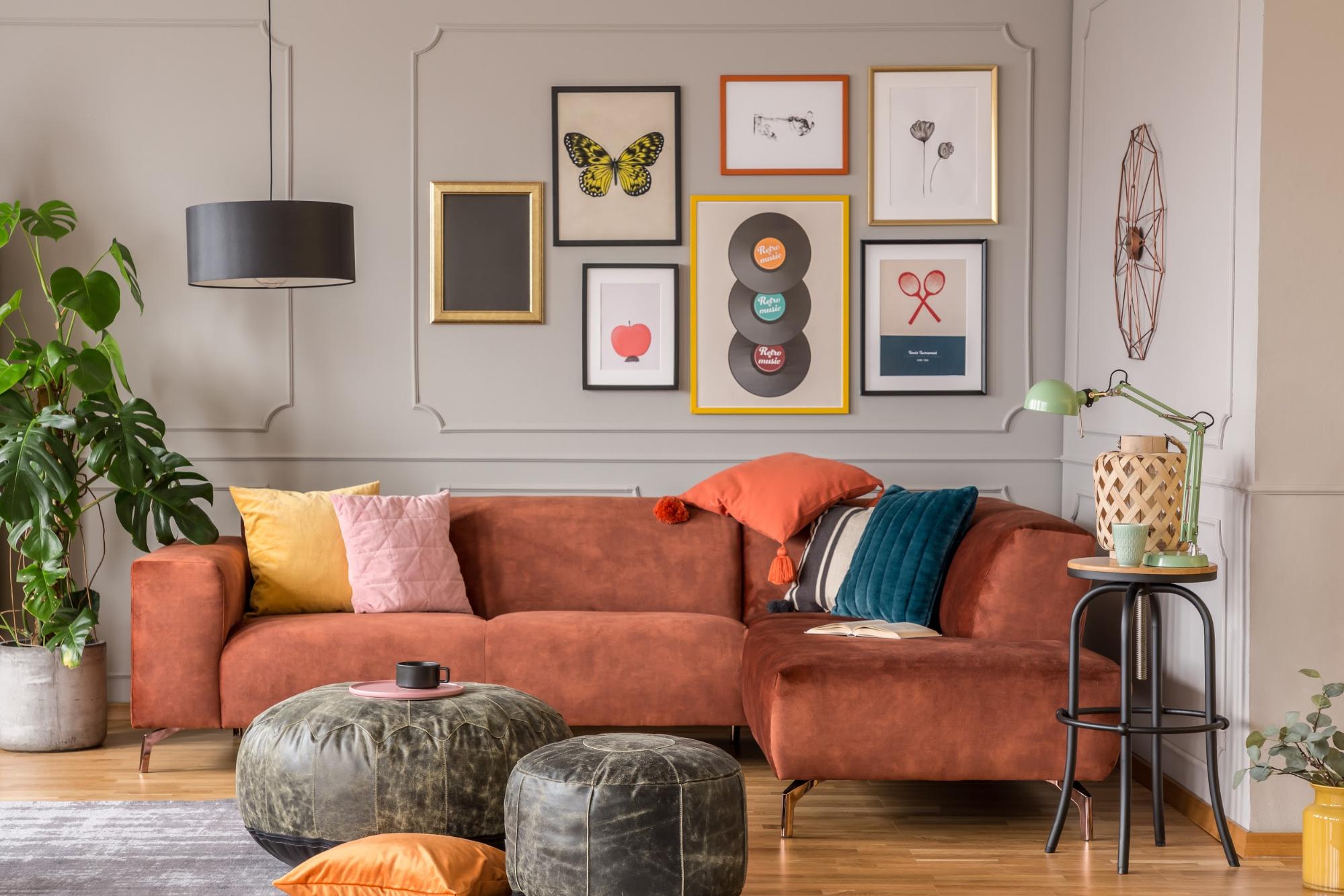 end table with storage: Living room with an orange couch and colorful pillows