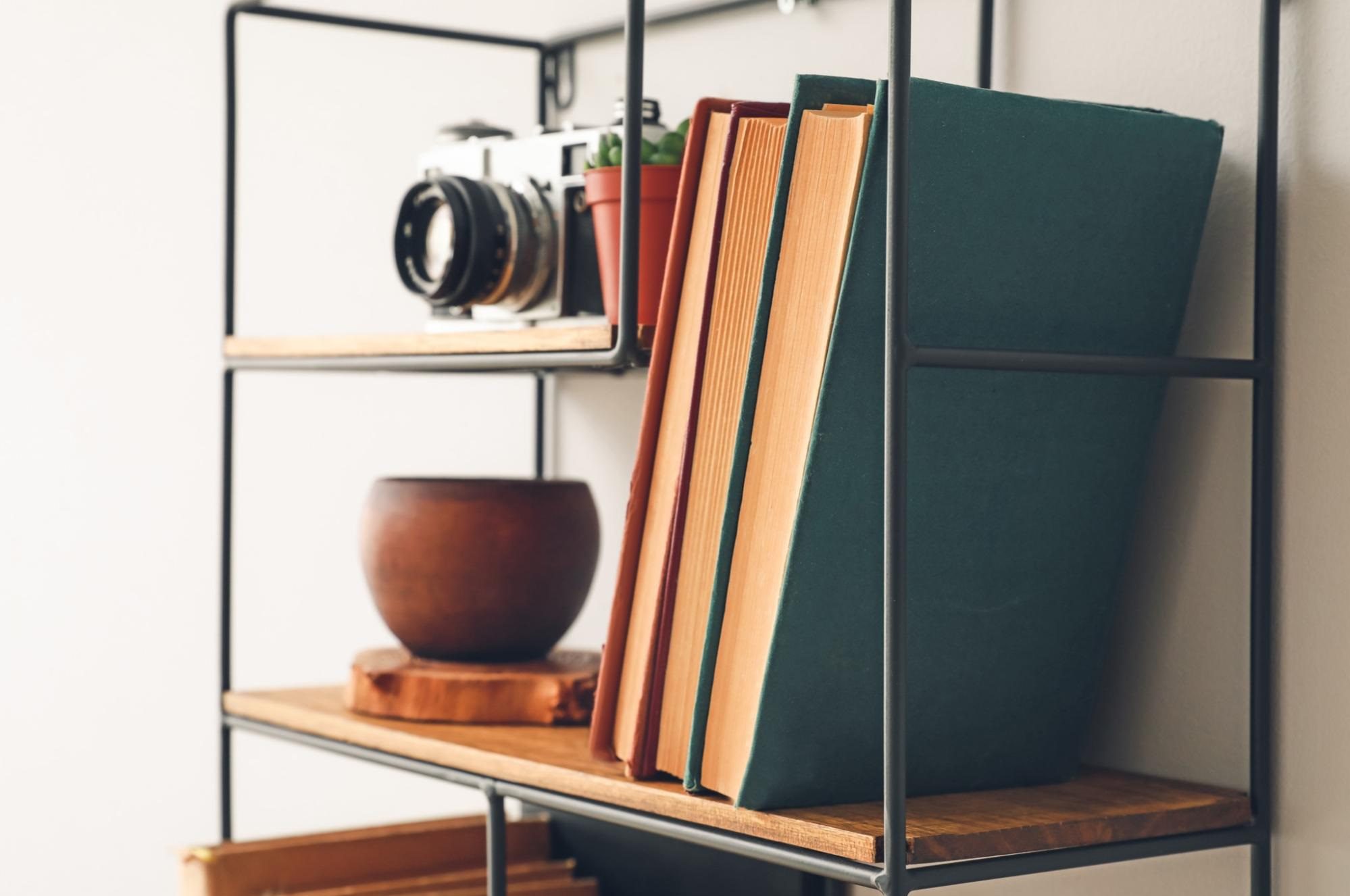 Books displayed backwards on a shelf with other decorations