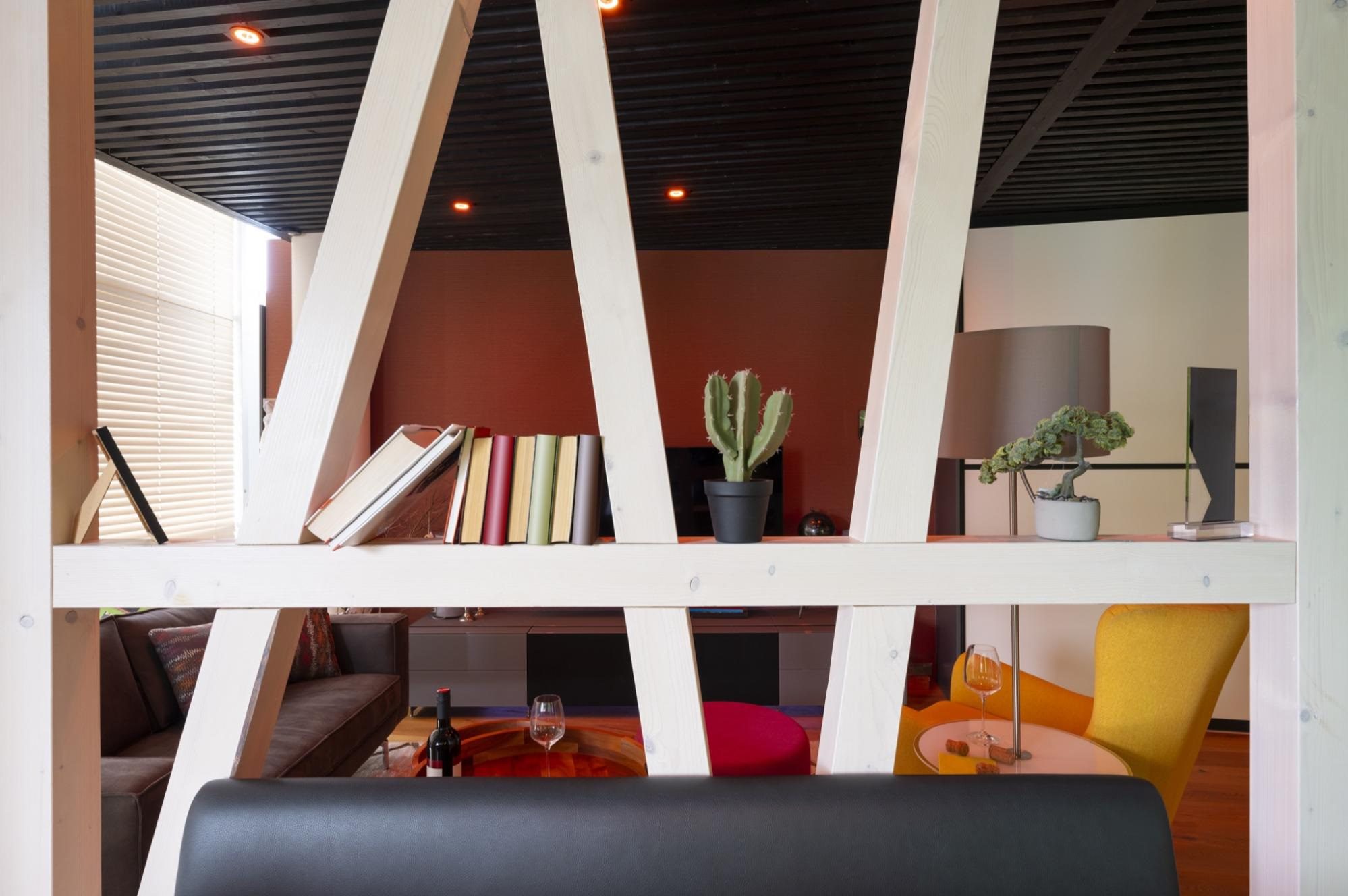 bookshelf ideas: White wooden beams with books and decorations used as a room divider