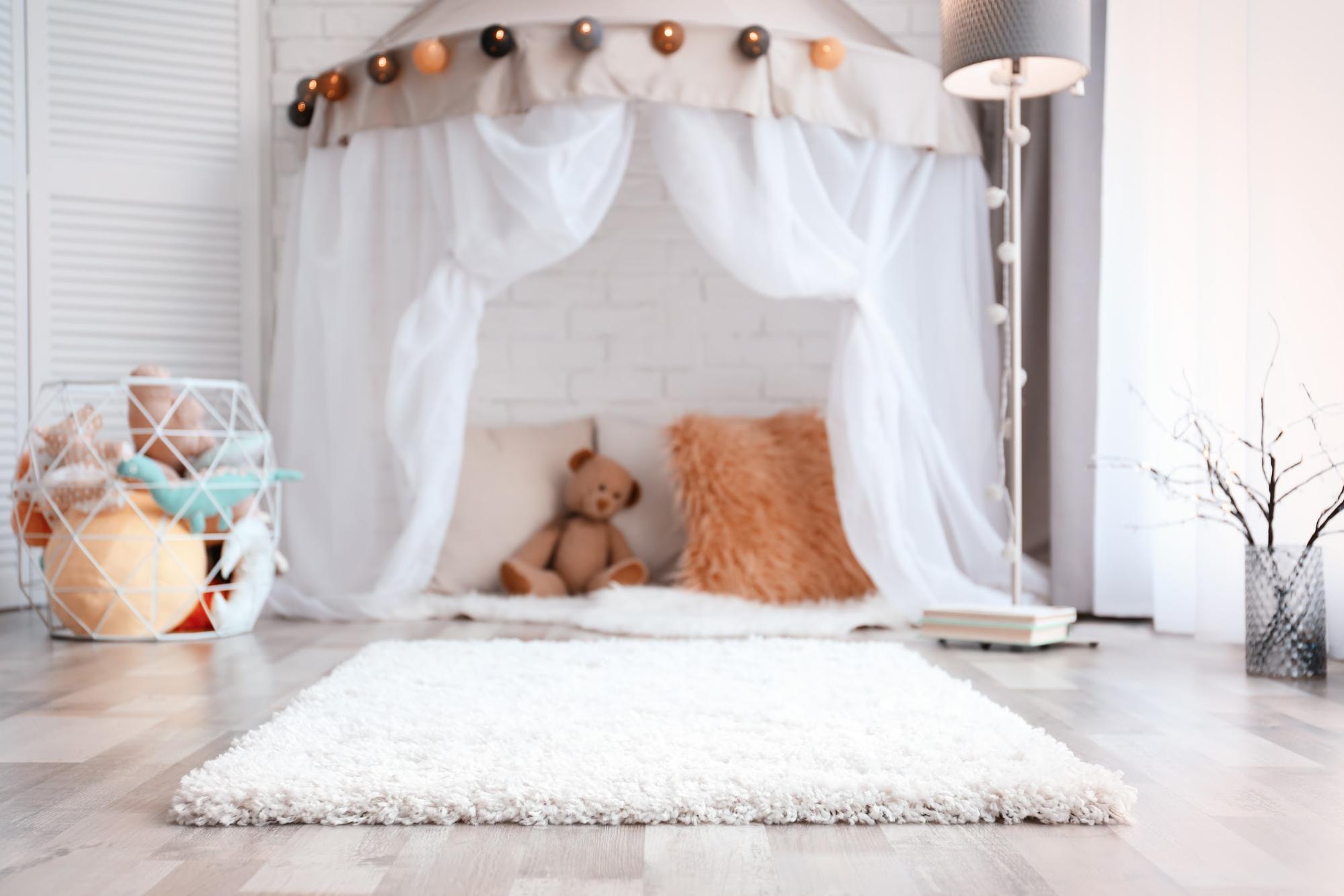 playroom ideas: pillows and teddy bear under a white canopy