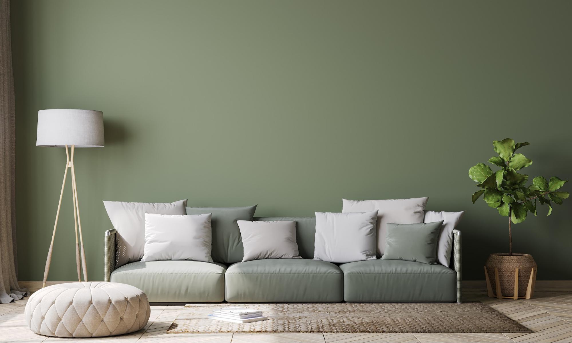 Modern living room with a green wall, green couch and white pillows