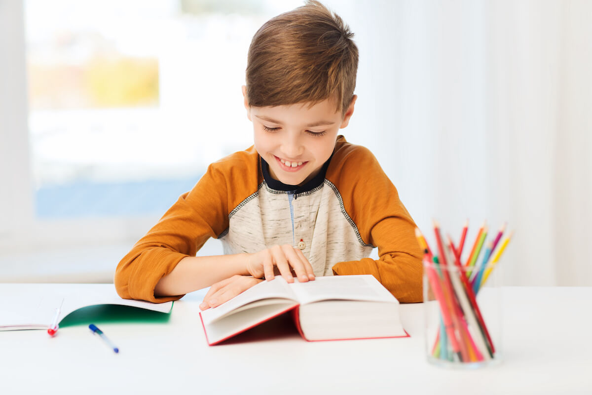 Little boy happily reading a book