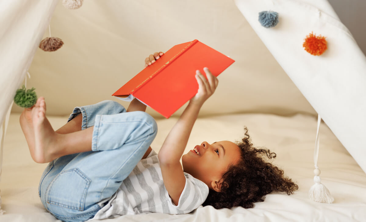 Little kid happily reading a book