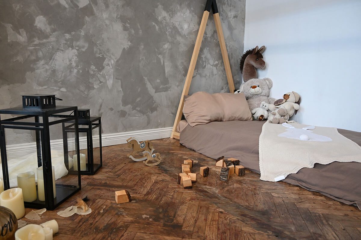 reading nook: Mattress, pillow, blanket, stuffed animals, candles and wooden toys on the floor