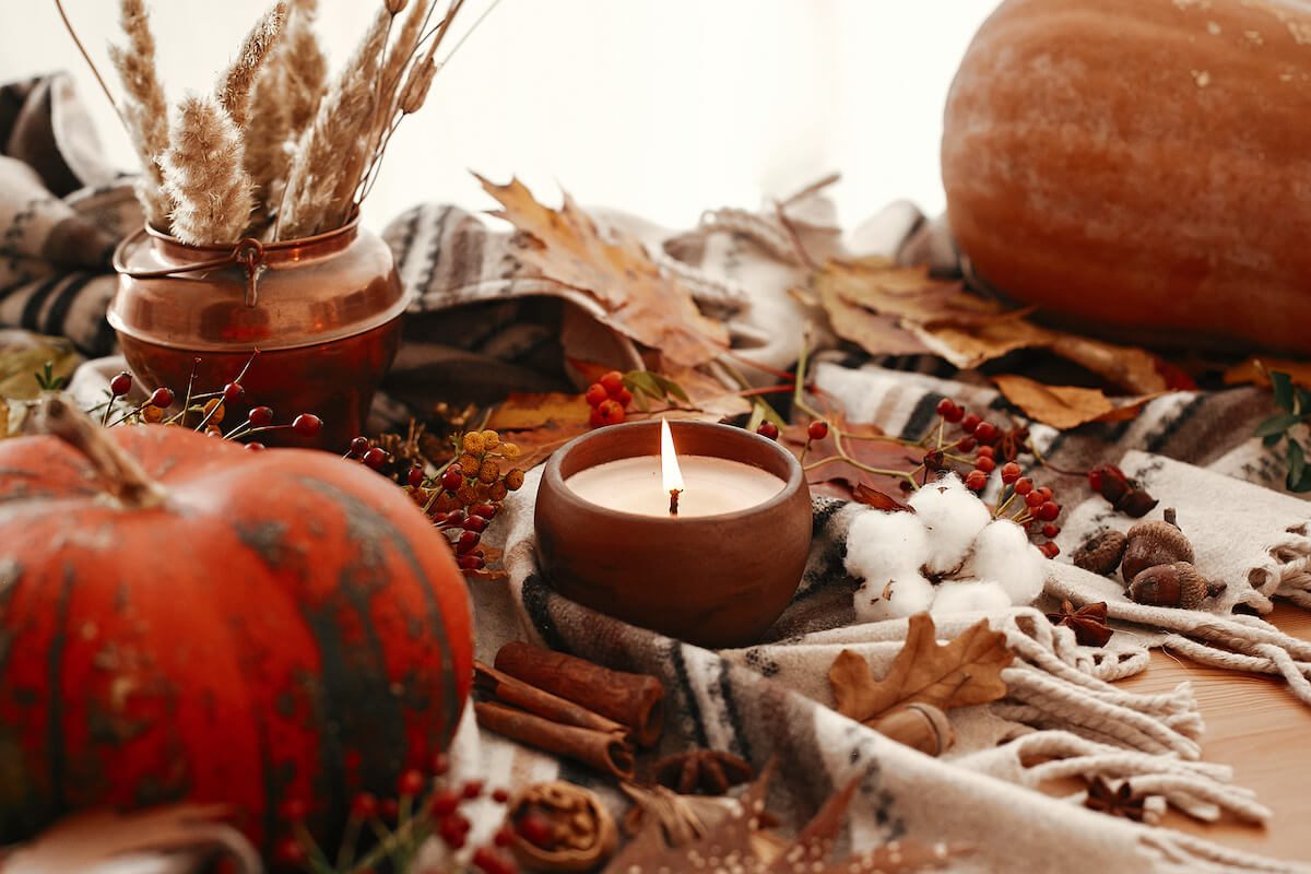 Pumpkin, lit candle and berries