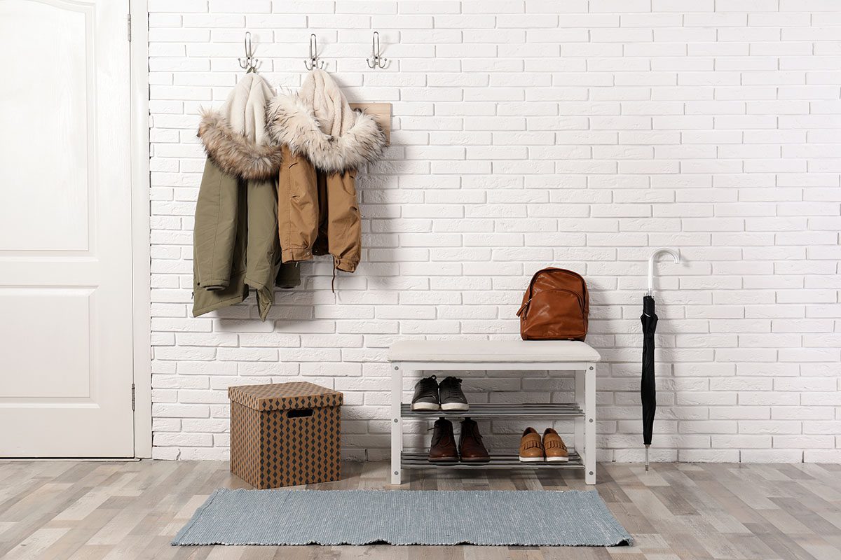 small shoe rack with coat hangers near a door