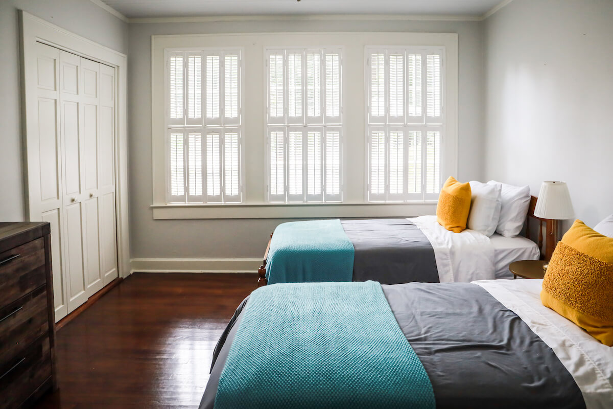 2 beds with teal blankets and yellow pillows